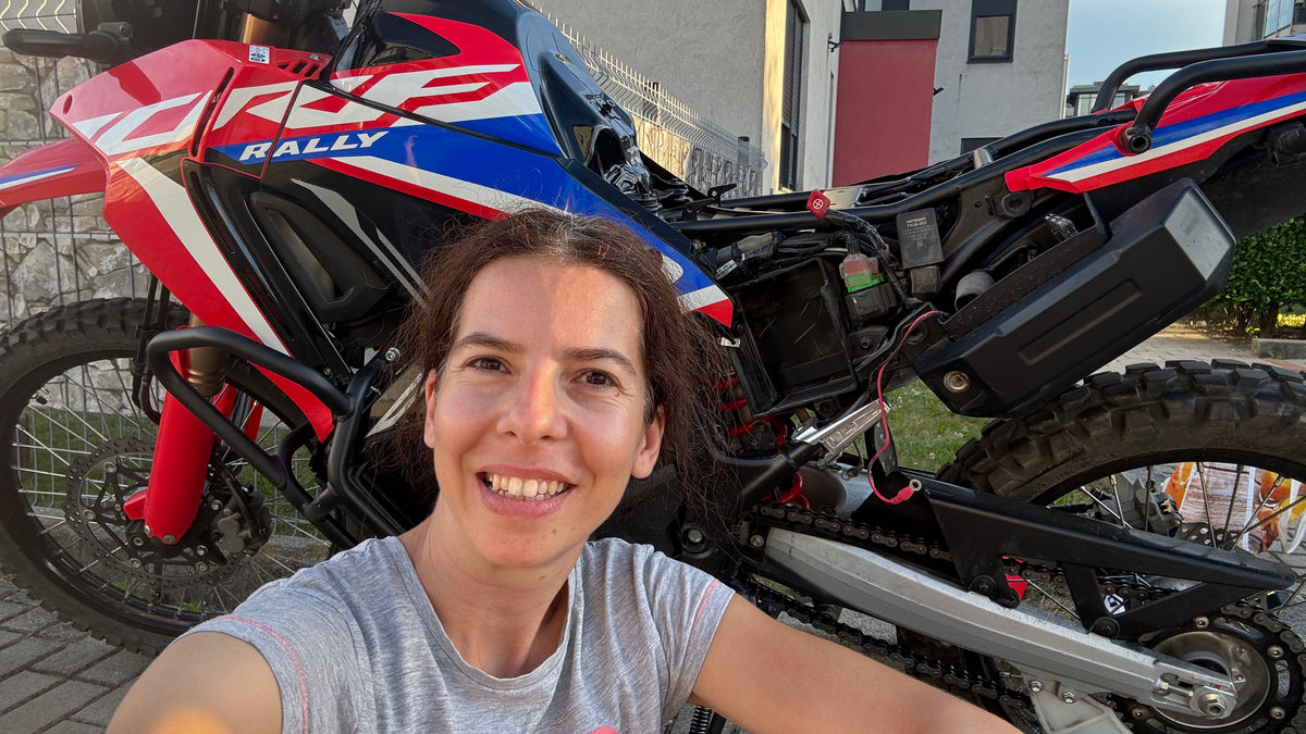 Szandi a Honda CRF300 Rally akkumulátorának szerelése közben, az indulás előtti felkészítésen.