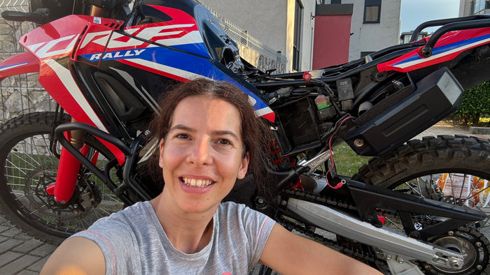 Szandi a Honda CRF300 Rally akkumulátorának szerelése közben, az indulás előtti felkészítésen.