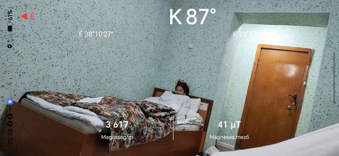 Szandi fekszik az ágyban közel a rosszullét határán a murghabi szálláson; a Honor Compass képernyőjén 3617 méteres magasság látszik.