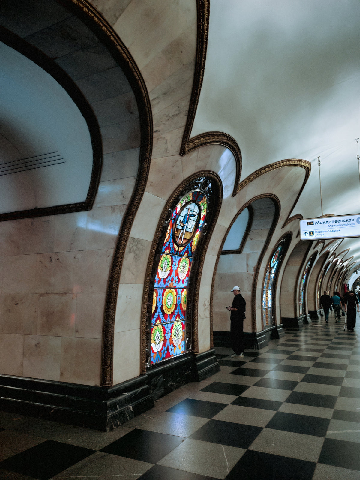 Ólomüveg ablakokkal díszített csarnok a moszkvai Novoszlobodszkaja metróállomáson.