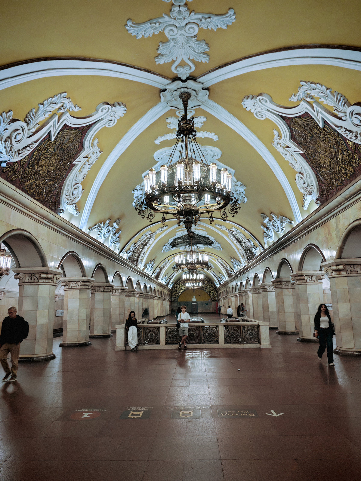 A moszkvai Komszomolszkaja metróállomás aranyszínű, gazdagon díszített csarnoka.