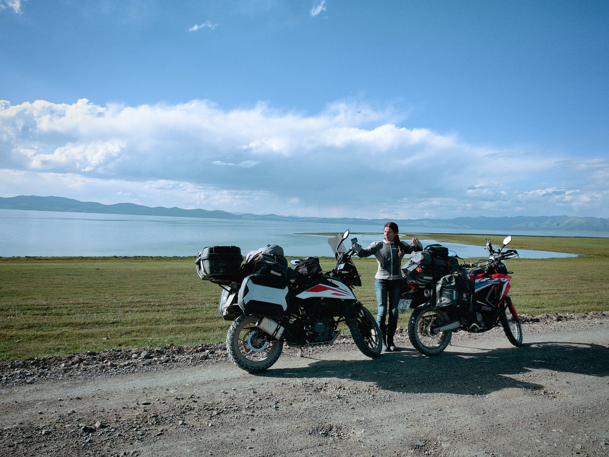 Szandi a Honda CRF 300 Rally és a KTM 390 Adventure mellett a Song-Köl partján.