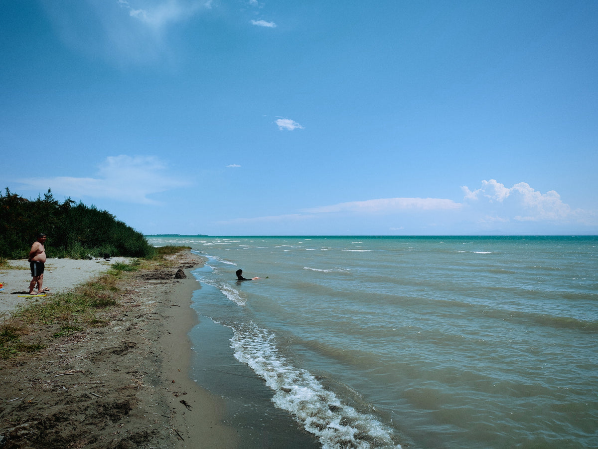 Az Issyk-Kul partja sekély hullámokkal és hegyekkel a távolban.
