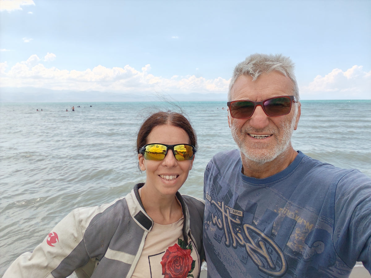 Szandi és Laci az Issyk-Kul partján, háttérben a tóval.