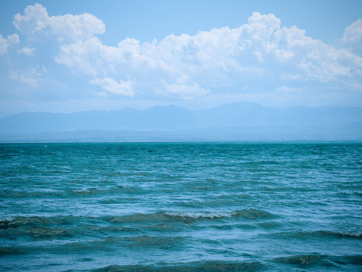 Az Issyk-Kul kék vízfelülete és a távoli hegyvonulat.