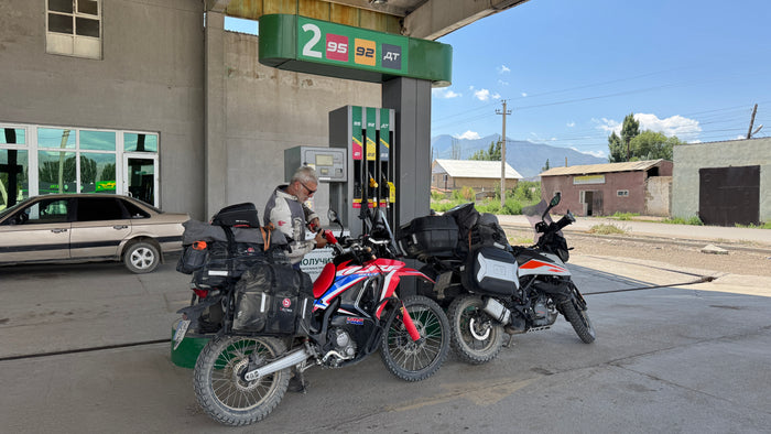 Laci a két felmálházott motorral egy 95-öst is kínáló benzinkútnál Kochkorban, Kirgizisztánban, 2026. július 26-án.
