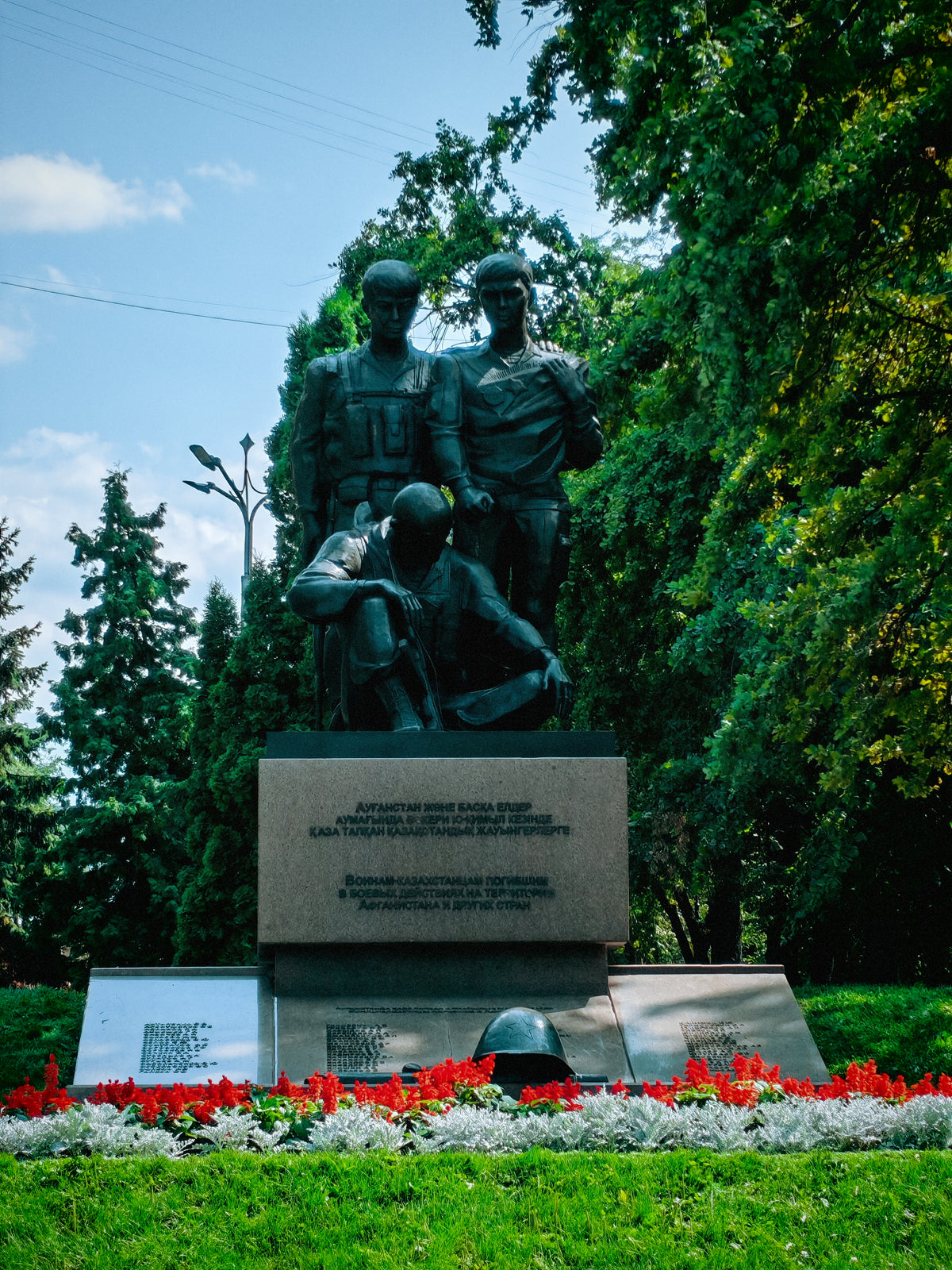 Katonai emlékszobor az almatyi Panfilov Park fái között.
