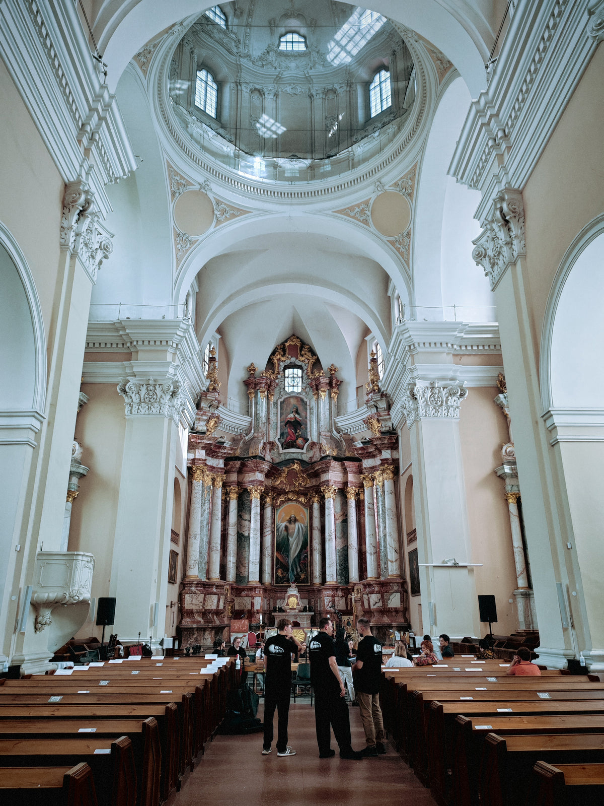 Világos, boltozatos templomhajó és oltár Vilniusban.