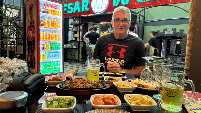 Laci a szamarkandi sarki étteremben a vacsoránál, sörrel és sushival az asztalon.